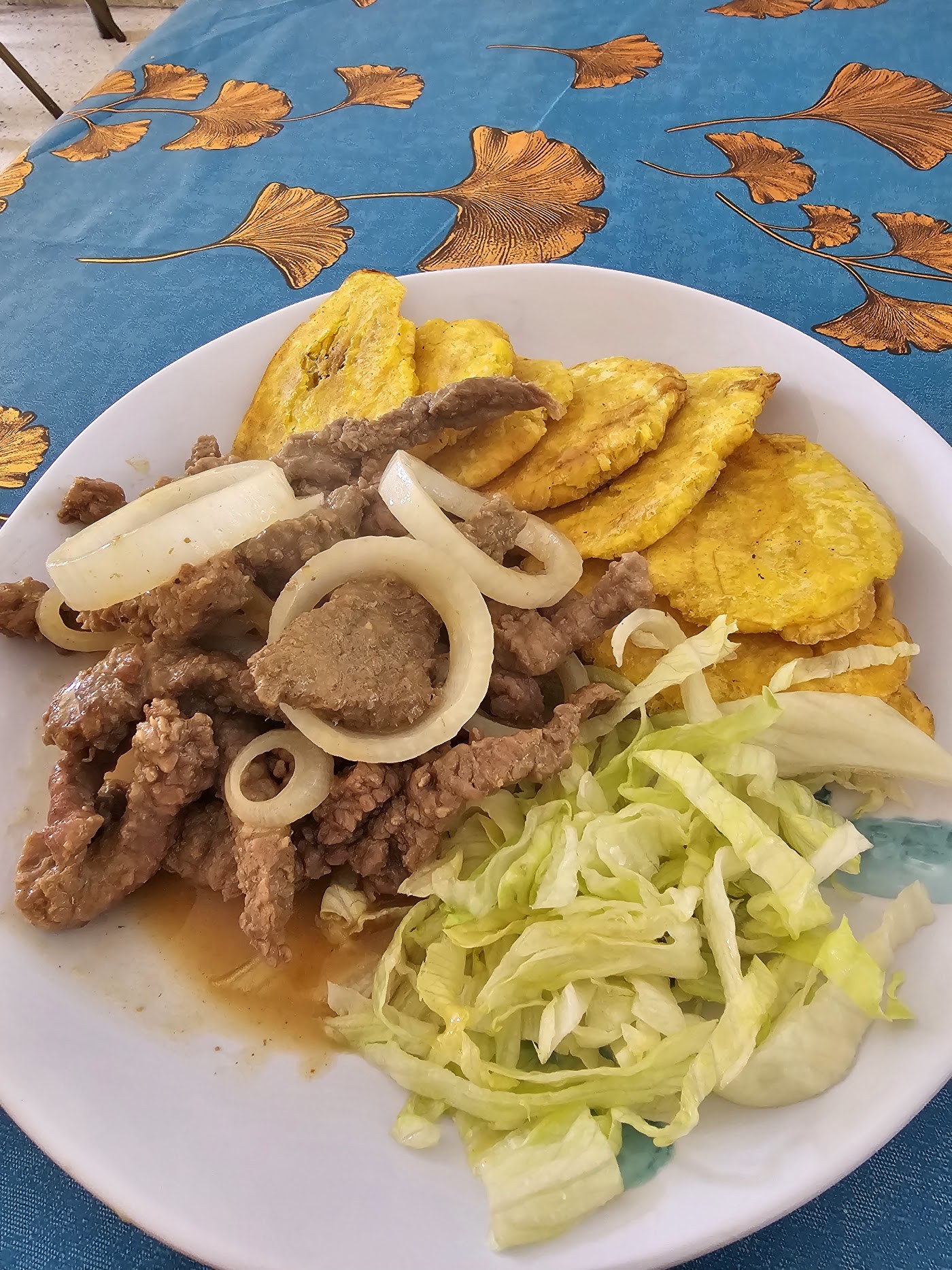 Bistec encebollado con tostones